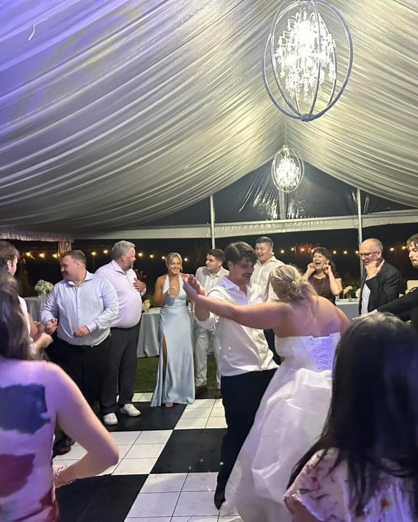 Bride and groomsmen dancing on a checkered dance floor