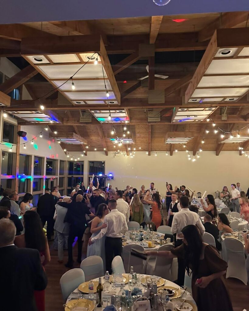 Wedding reception tables and dance floor in a hall with large windows